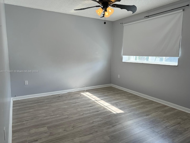 spare room featuring ceiling fan, wood-type flooring, and a textured ceiling