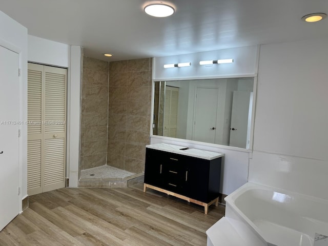 bathroom with vanity, wood-type flooring, and shower with separate bathtub