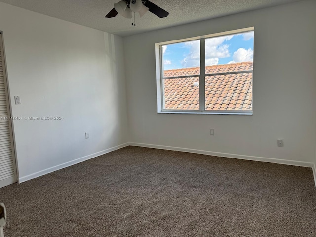 unfurnished room featuring ceiling fan, carpet floors, and a textured ceiling