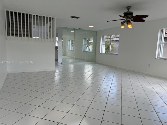 spare room featuring ceiling fan and light tile patterned floors