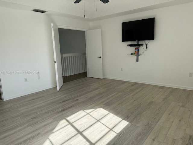 interior space with ceiling fan, light hardwood / wood-style floors, and a textured ceiling