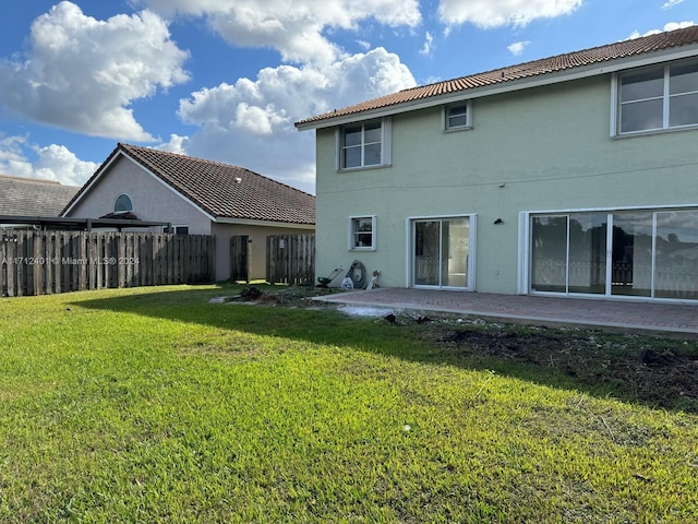 back of house featuring a patio area and a yard