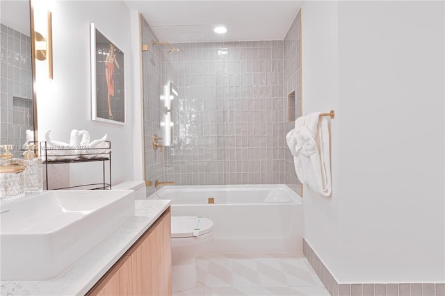 full bathroom featuring tile patterned flooring, vanity, toilet, and tiled shower / bath