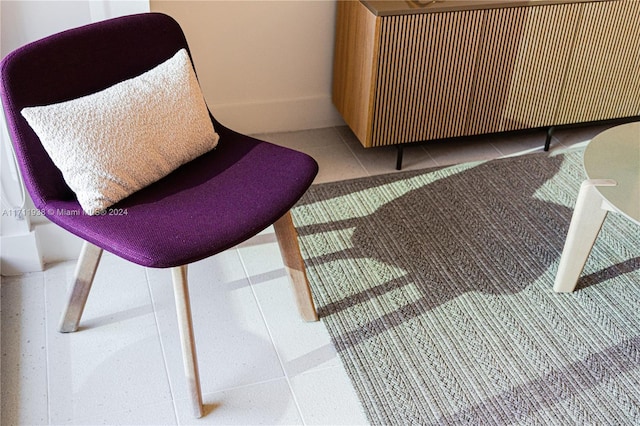 living area featuring radiator and light tile patterned floors