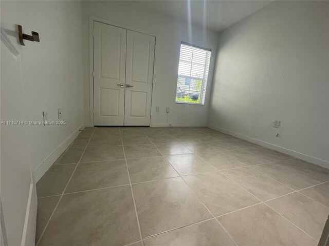 495 NE 5th Ln, Florida City, FL 33034 - unfurnished bedroom featuring tile patterned flooring and baseboards