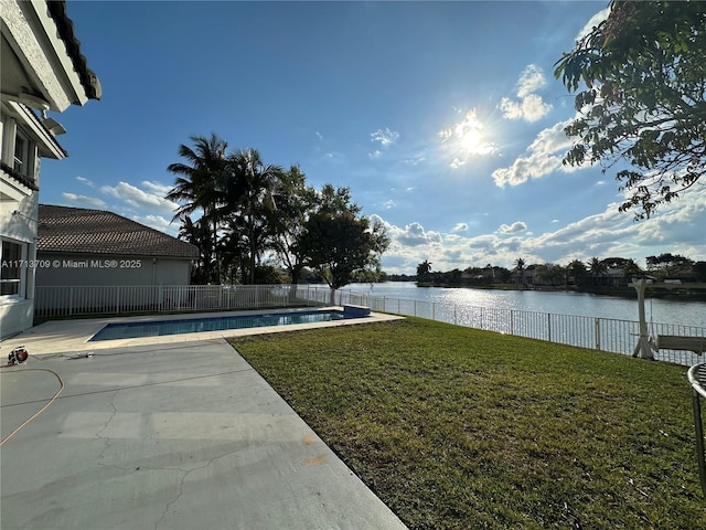 view of yard featuring a fenced in pool, fence, a patio, and a water view