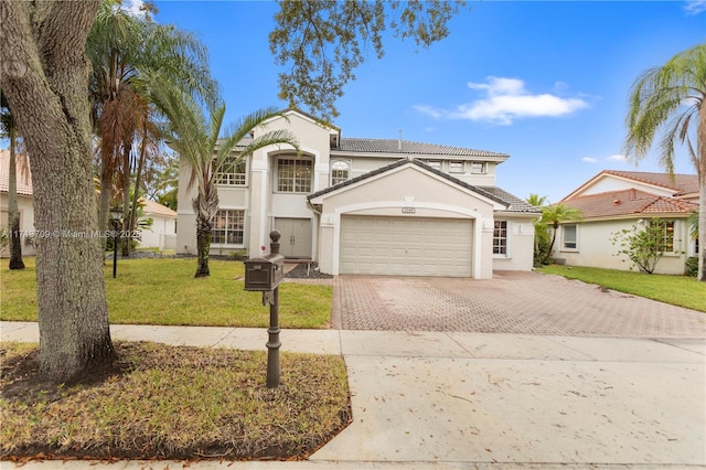 view of front of property with decorative driveway, stucco siding, an attached garage, a front yard, and a tiled roof