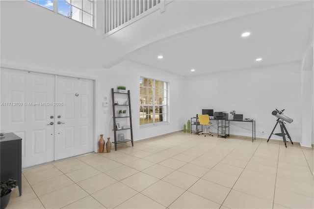 foyer entrance featuring a high ceiling, light tile patterned floors, recessed lighting, and baseboards