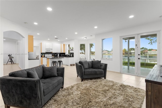 living area with recessed lighting, french doors, arched walkways, and light tile patterned floors