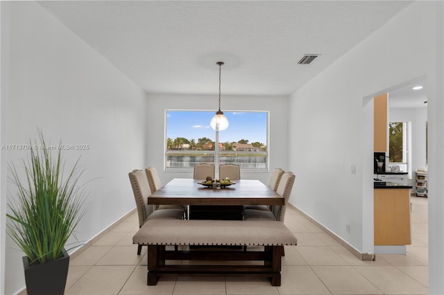 dining room with light tile patterned flooring, visible vents, and baseboards