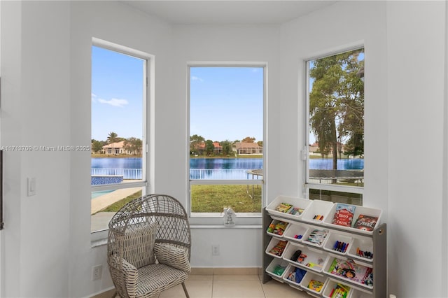 sunroom featuring a water view