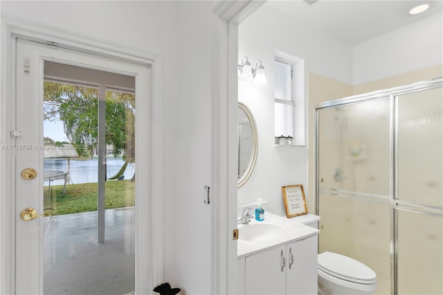 full bath featuring toilet, a stall shower, and vanity