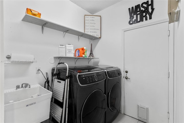 washroom featuring washer and dryer, laundry area, light tile patterned flooring, and a sink