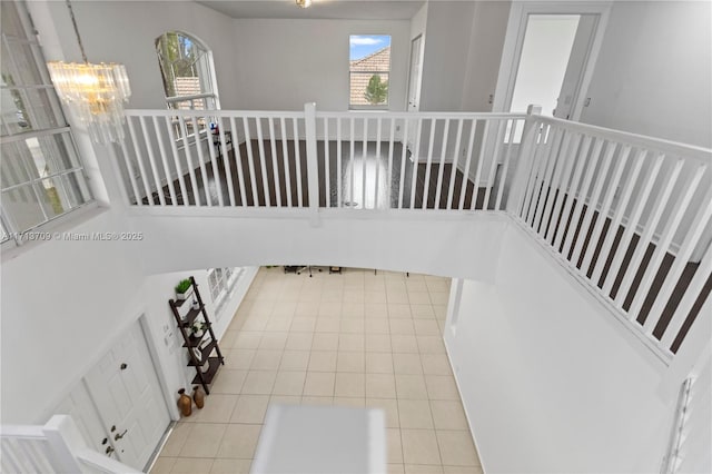 stairway featuring tile patterned floors and a notable chandelier