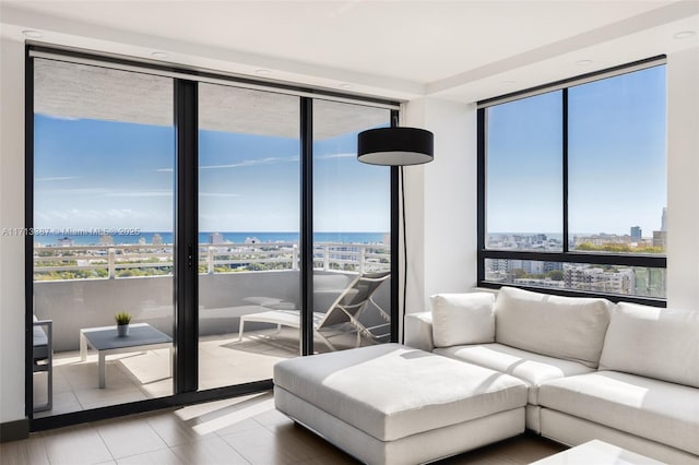 living room featuring a water view, tile patterned floors, and floor to ceiling windows