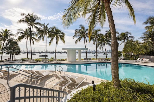 view of pool featuring a water view and a patio area