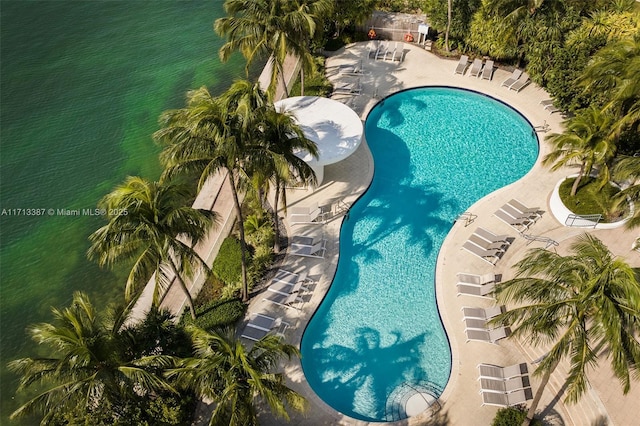 view of swimming pool featuring a patio area and a water view