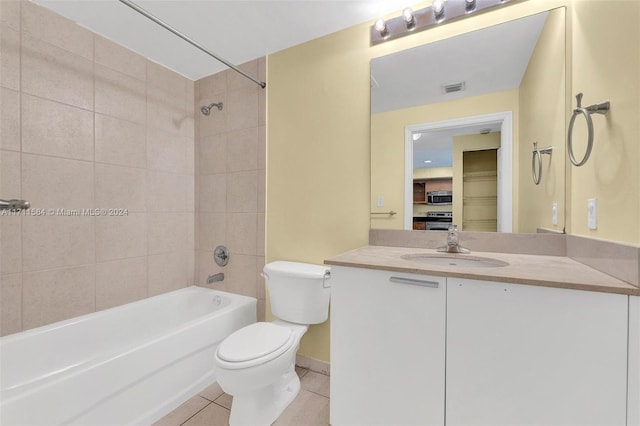 full bathroom featuring tile patterned flooring, vanity, tiled shower / bath combo, and toilet