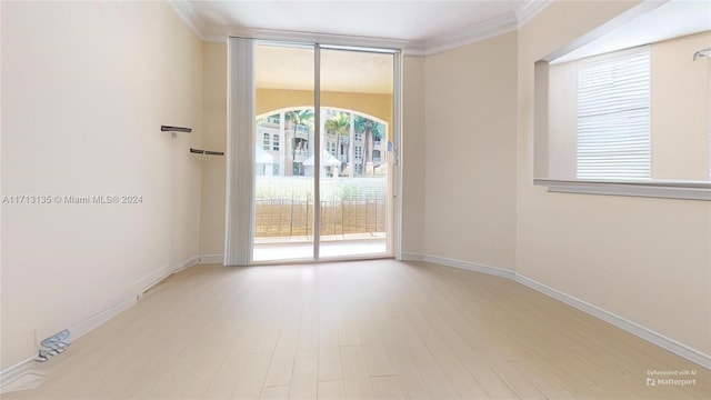 spare room featuring crown molding and light hardwood / wood-style flooring