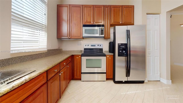 kitchen featuring light stone countertops and stainless steel appliances