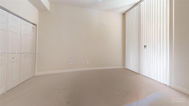 unfurnished bedroom featuring light colored carpet and a closet