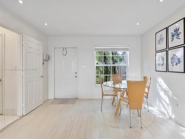 dining area with baseboards, light wood finished floors, and recessed lighting