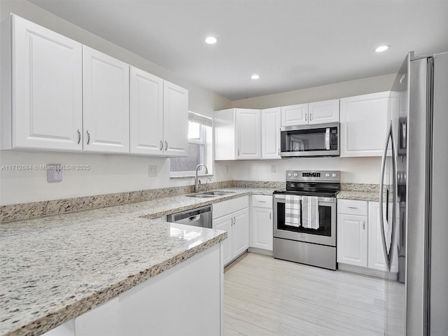 kitchen featuring appliances with stainless steel finishes, a sink, white cabinetry, and recessed lighting