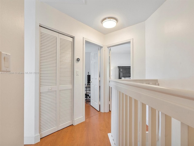 corridor with baseboards and light wood-style floors