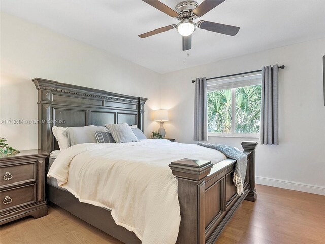 bedroom with light wood-style floors, baseboards, and ceiling fan