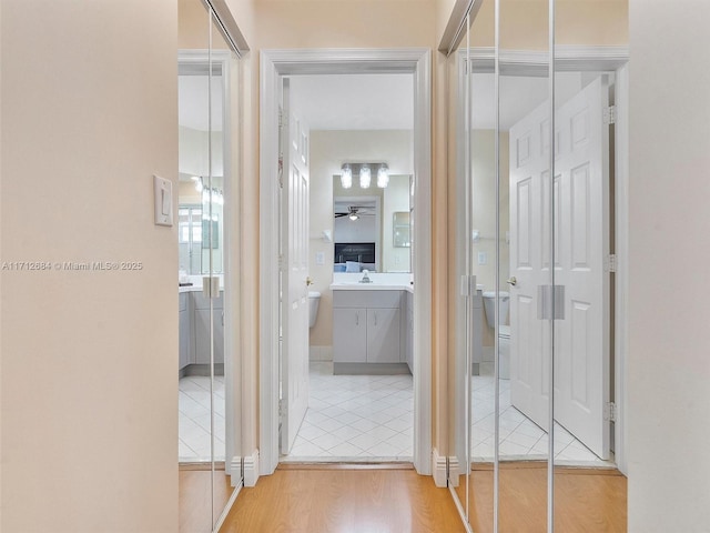 hallway featuring wood finished floors and a sink