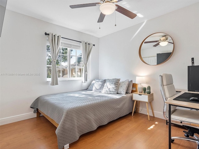 bedroom with light wood-style floors, baseboards, and ceiling fan