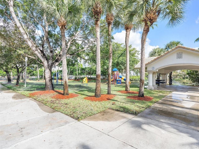 surrounding community featuring a yard, driveway, and playground community