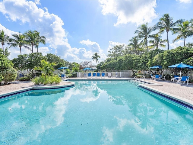 community pool featuring a patio and fence