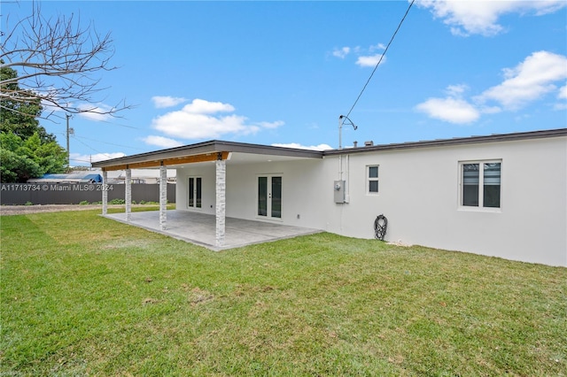 back of property with a patio and a lawn