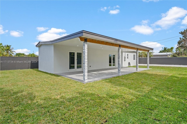 rear view of property featuring a yard and a patio area