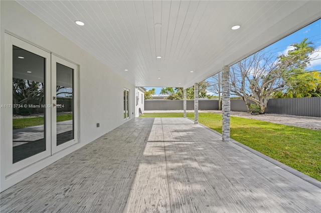 wooden deck with a patio, a lawn, and french doors