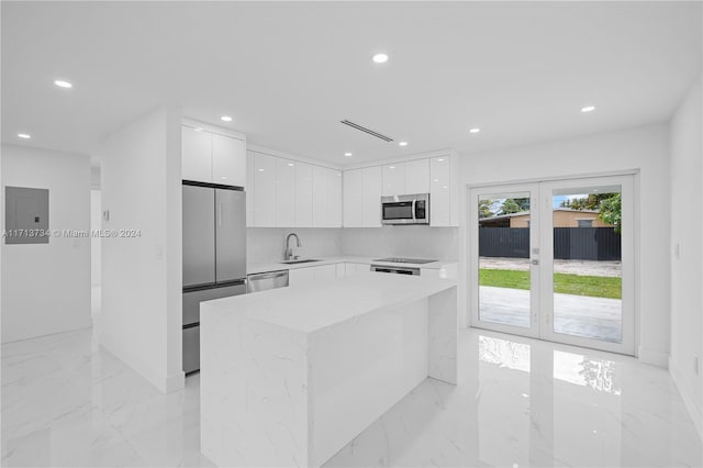 kitchen with white cabinetry, sink, a center island, electric panel, and stainless steel appliances