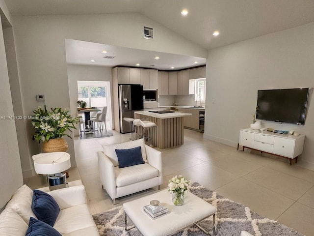 living room with a healthy amount of sunlight, recessed lighting, visible vents, and lofted ceiling