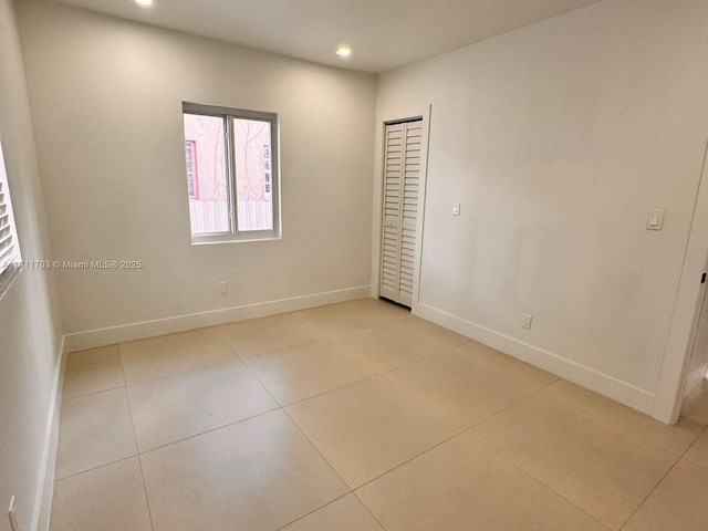 unfurnished room with recessed lighting, baseboards, and light tile patterned flooring