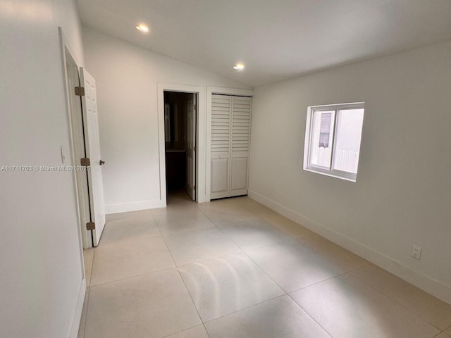 unfurnished bedroom featuring lofted ceiling, light tile patterned floors, baseboards, and recessed lighting