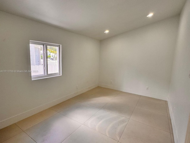 empty room featuring light tile patterned floors, recessed lighting, and baseboards