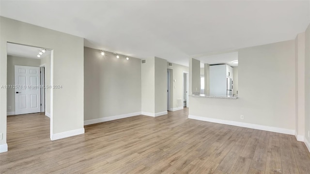 spare room with light wood-type flooring and track lighting