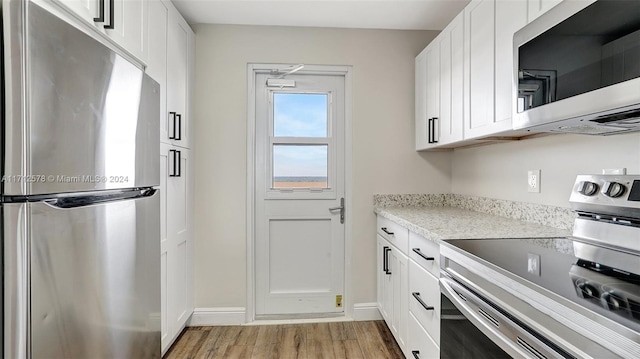 kitchen featuring white cabinetry, stainless steel appliances, and light wood-type flooring