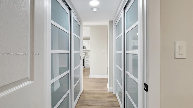 hallway featuring french doors and light wood-type flooring