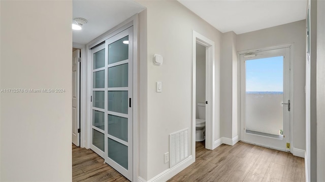 hallway with light hardwood / wood-style floors