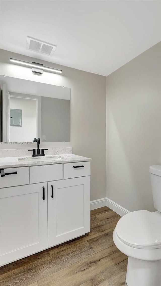 bathroom with hardwood / wood-style flooring, vanity, and toilet