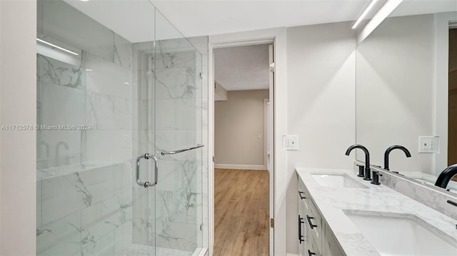 bathroom featuring hardwood / wood-style flooring, vanity, and a shower with door