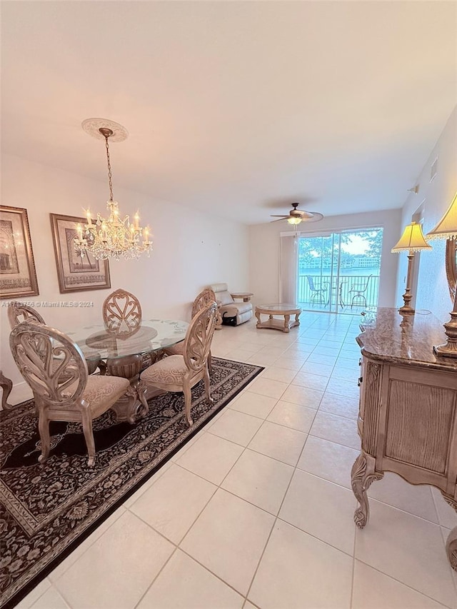 dining area with light tile patterned floors and ceiling fan with notable chandelier