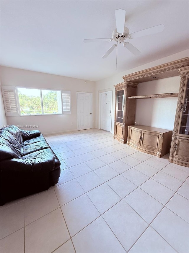 unfurnished living room with ceiling fan and light tile patterned flooring