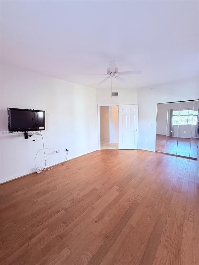 unfurnished living room featuring ceiling fan and hardwood / wood-style floors